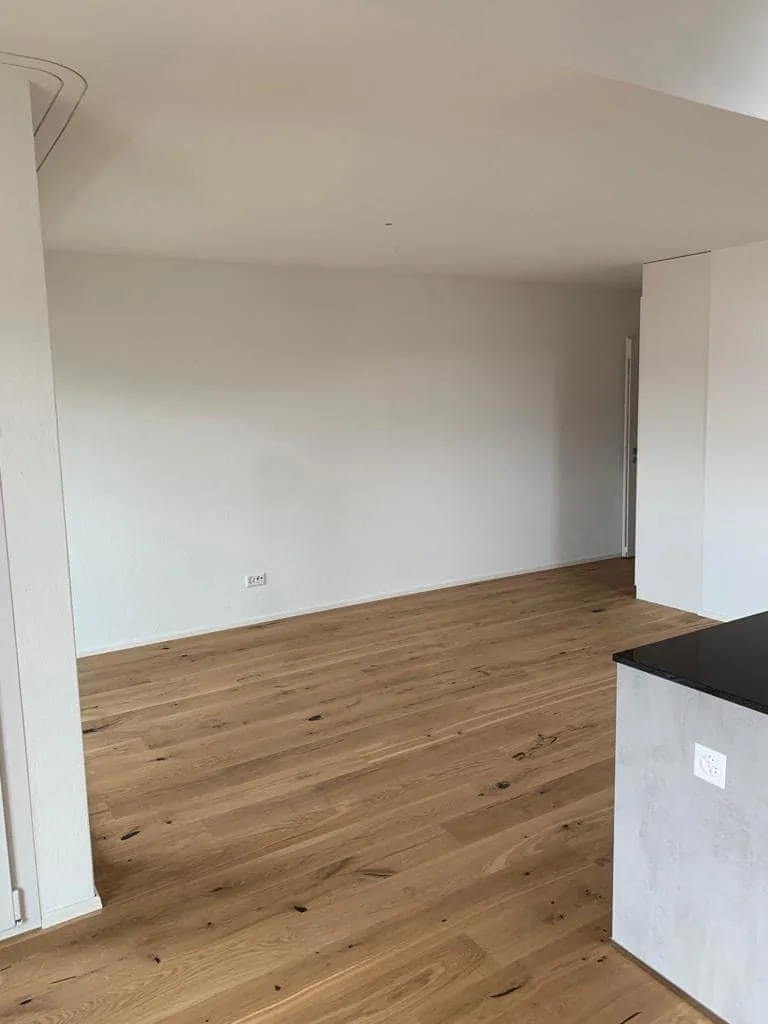 Baufirma Zürich — Wohnraum mit Sichtbeton-Küchenblock nach Totalsanierung, MFH Ennetbaden